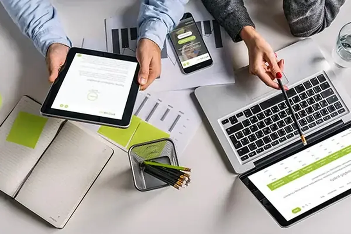 Tablet i laptop z dokumentami na biurku — porównywanie narzędzi dla firmy