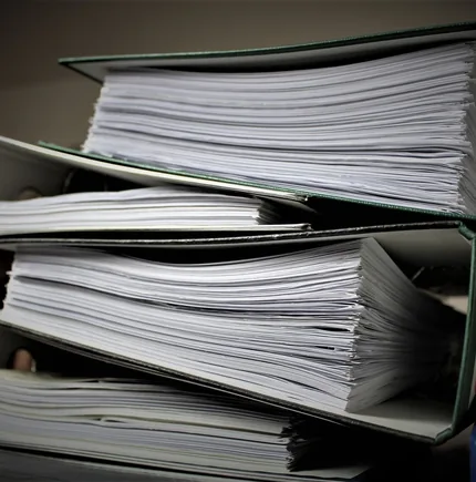 Close-up of stacked binders filled with documents for office or educational use.