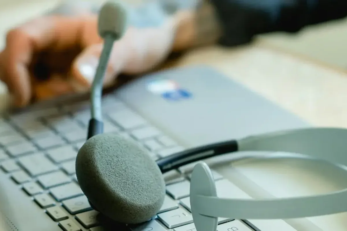 Zestaw słuchawkowy z mikrofonem na klawiaturze laptopa — obsługa zgłoszeń helpdesk