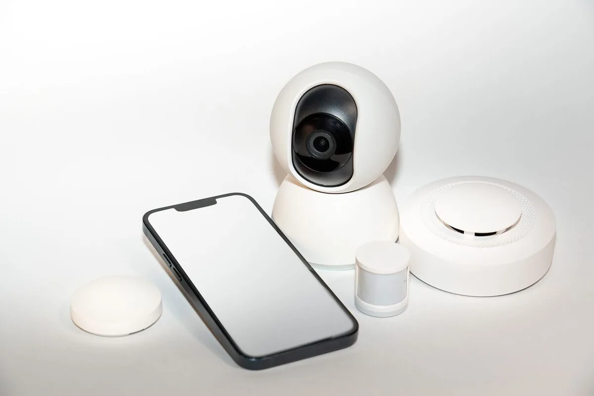 Zestaw urządzeń smart home: kamera, czujniki i telefon na białym tle — Padła sieć domowa i nie działają smart TV oraz inne urządzenia