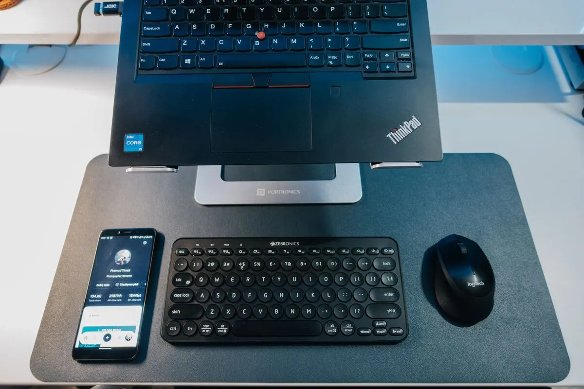 Laptop Lenovo ThinkPad na biurku obok klawiatury i myszy — Naprawa klawiatury i myszy bezprzewodowej