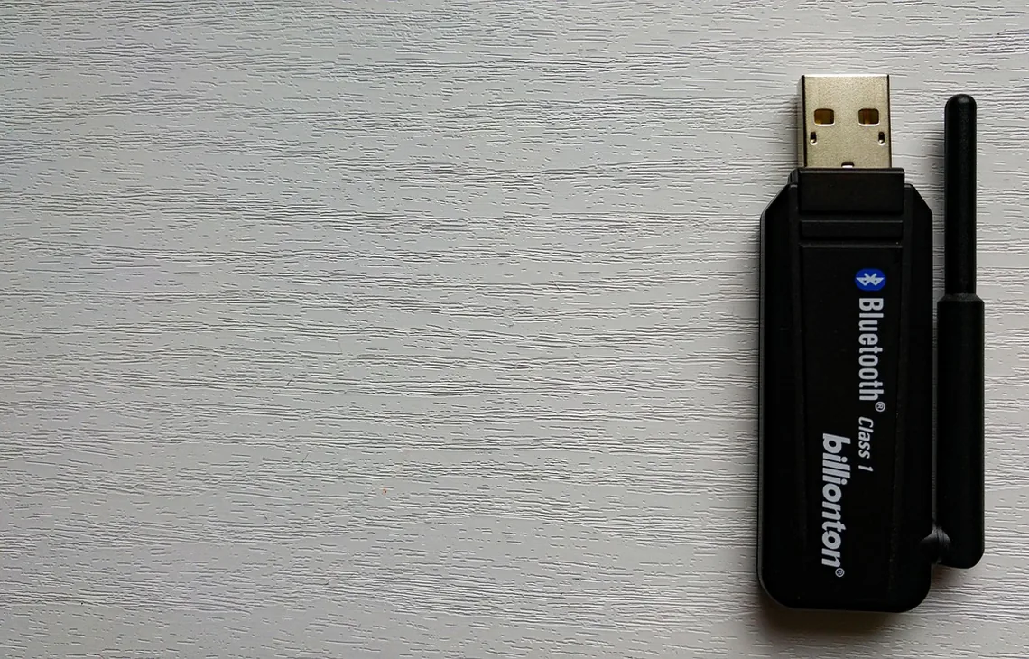 Adapter USB Bluetooth klasy 1 leżący na drewnianym blacie — Laptop traci połączenie Bluetooth