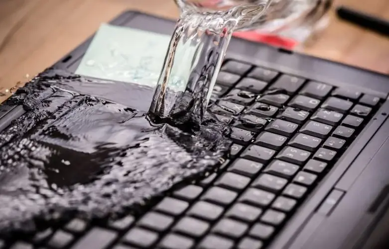 Woda wylewająca się na klawiaturę czarnego laptopa — Specjalizujemy się w naprawach po zalaniu cieczami innymi niż woda