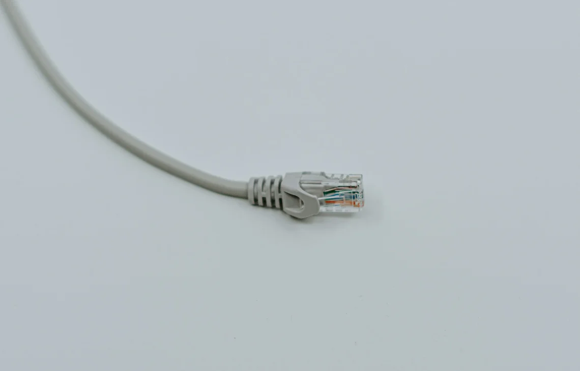 Kabel sieciowy Ethernet ze złączem RJ45 na jasnym tle — Naprawa portu Ethernet (RJ45) w laptopie