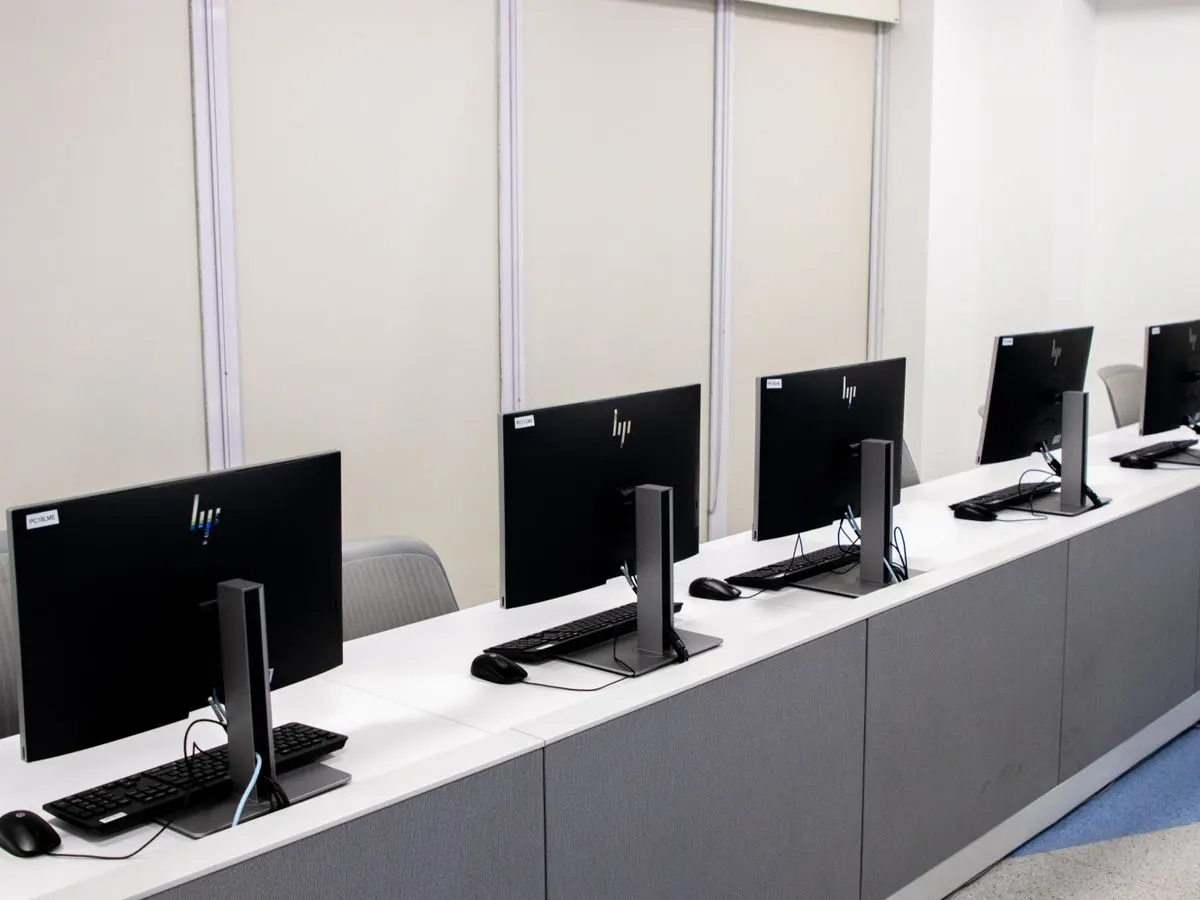 Rząd nowych komputerów ustawionych na biurku w pustym biurze — Zmiana dostawcy internetu i migracja łącza w biurze bez przestoju