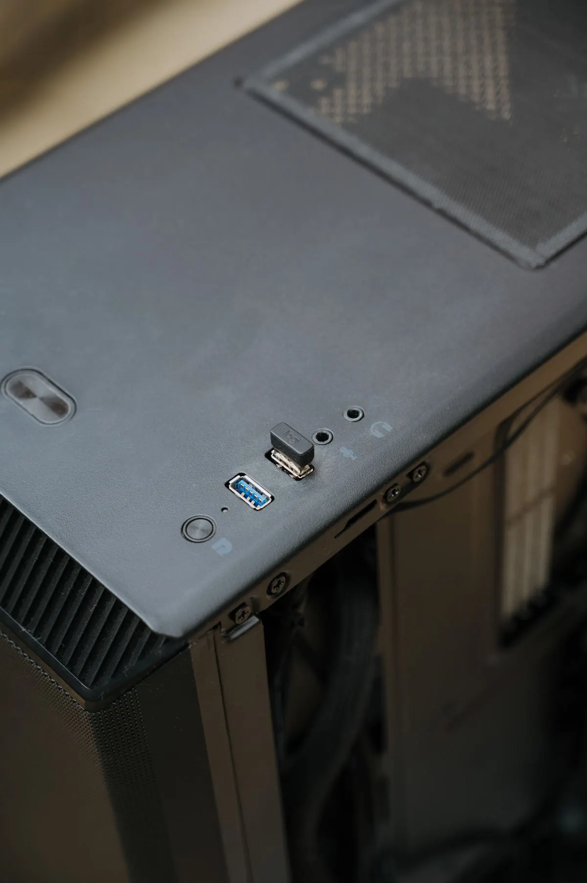 Zbliżenie górnego panelu obudowy komputera z przyciskiem power i portami USB — Komputer nie chce się poprawnie wyłączyć