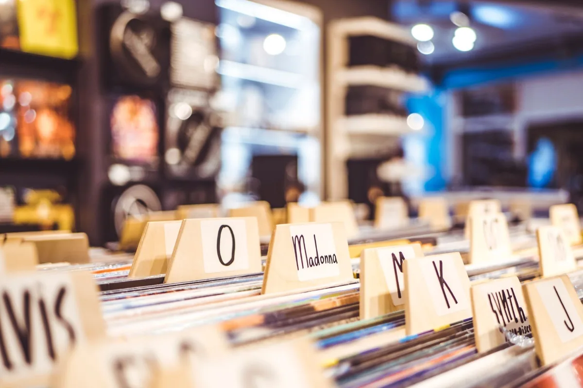 Close-up of vinyl records organized alphabetically in a music store.