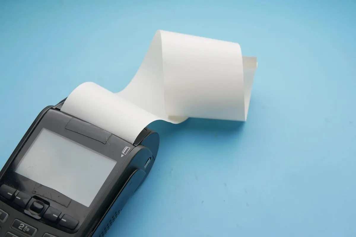 Drukarka fiskalna z rolką papieru na niebieskim tle — Drukarka nie działa przed pilnym wydrukiem dokumentu