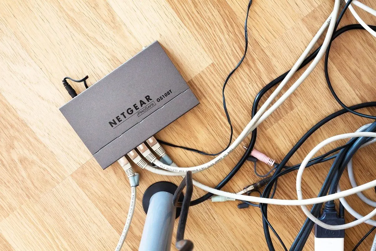 Router z podłączonymi kablami sieciowymi na biurku — Zarządzanie drukarkami sieciowymi i kosztami druku w firmie