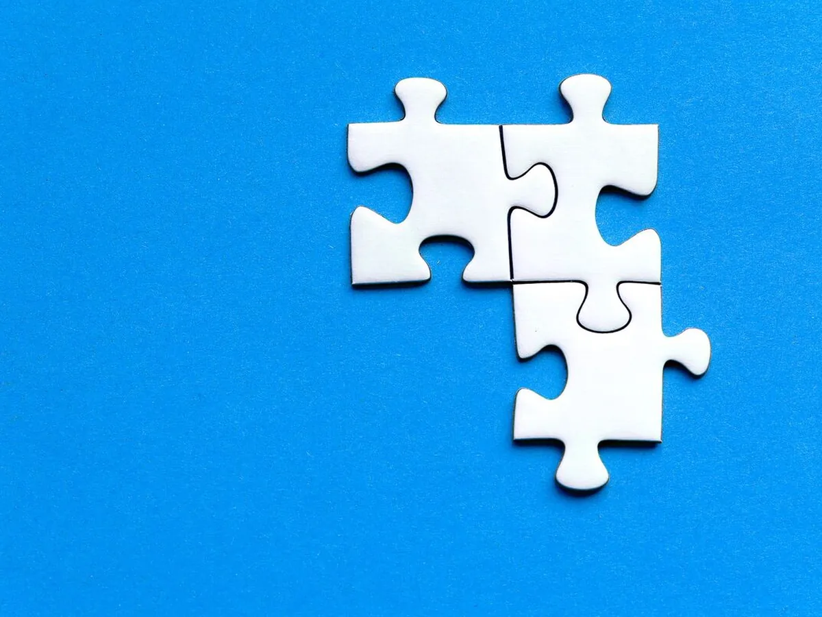 Cztery białe elementy układanki puzzle na niebieskim tle