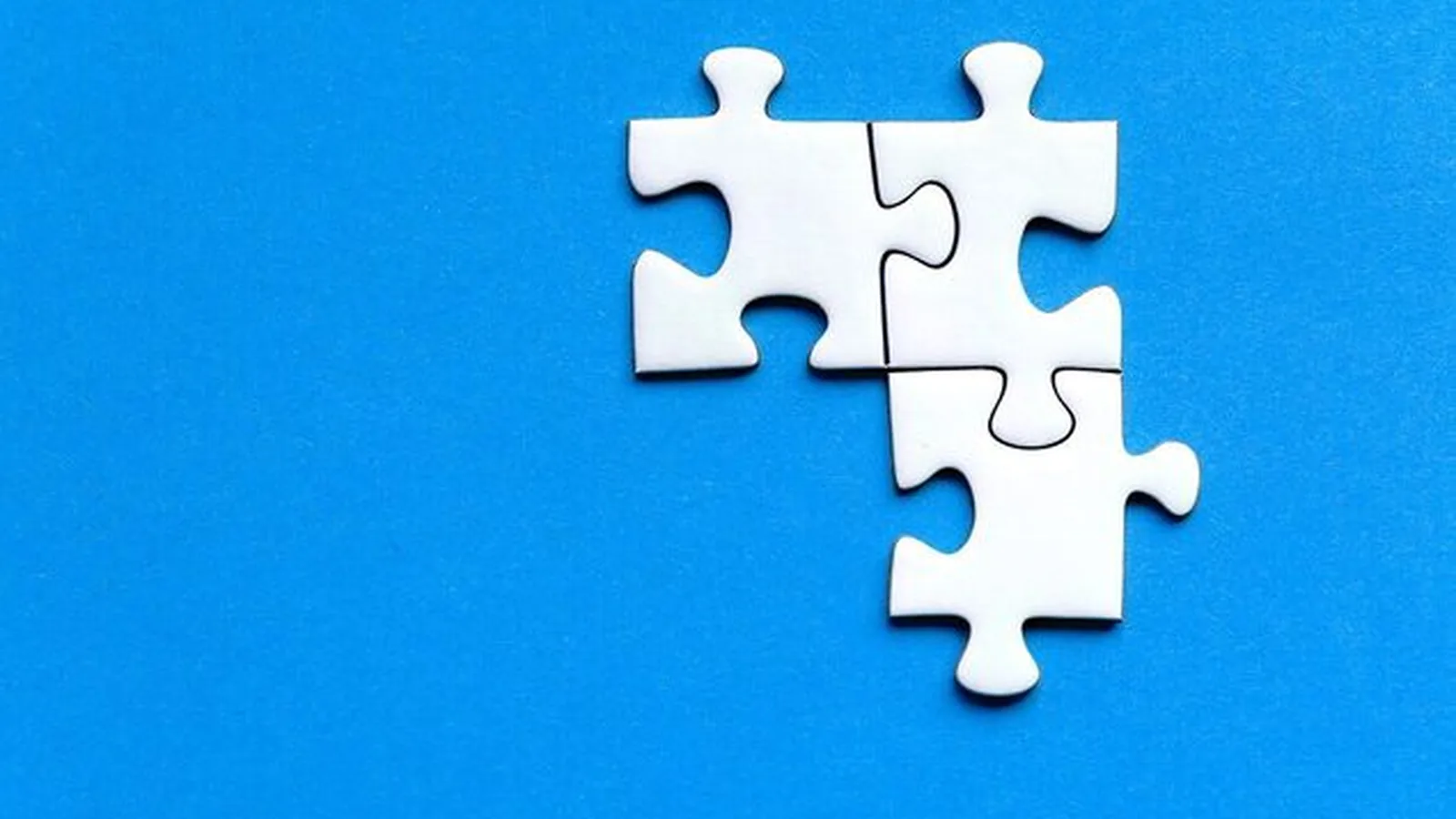 Cztery białe elementy układanki puzzle na niebieskim tle