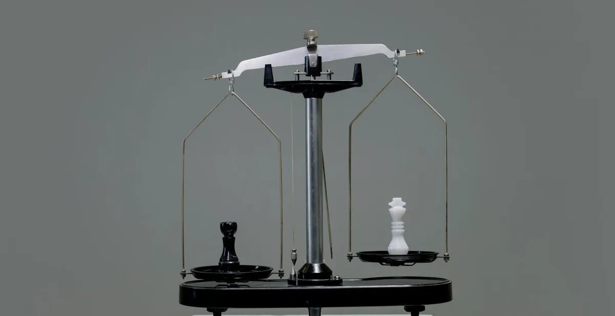 Chess pieces balanced on a scale depicting equality or strategy in decision making.