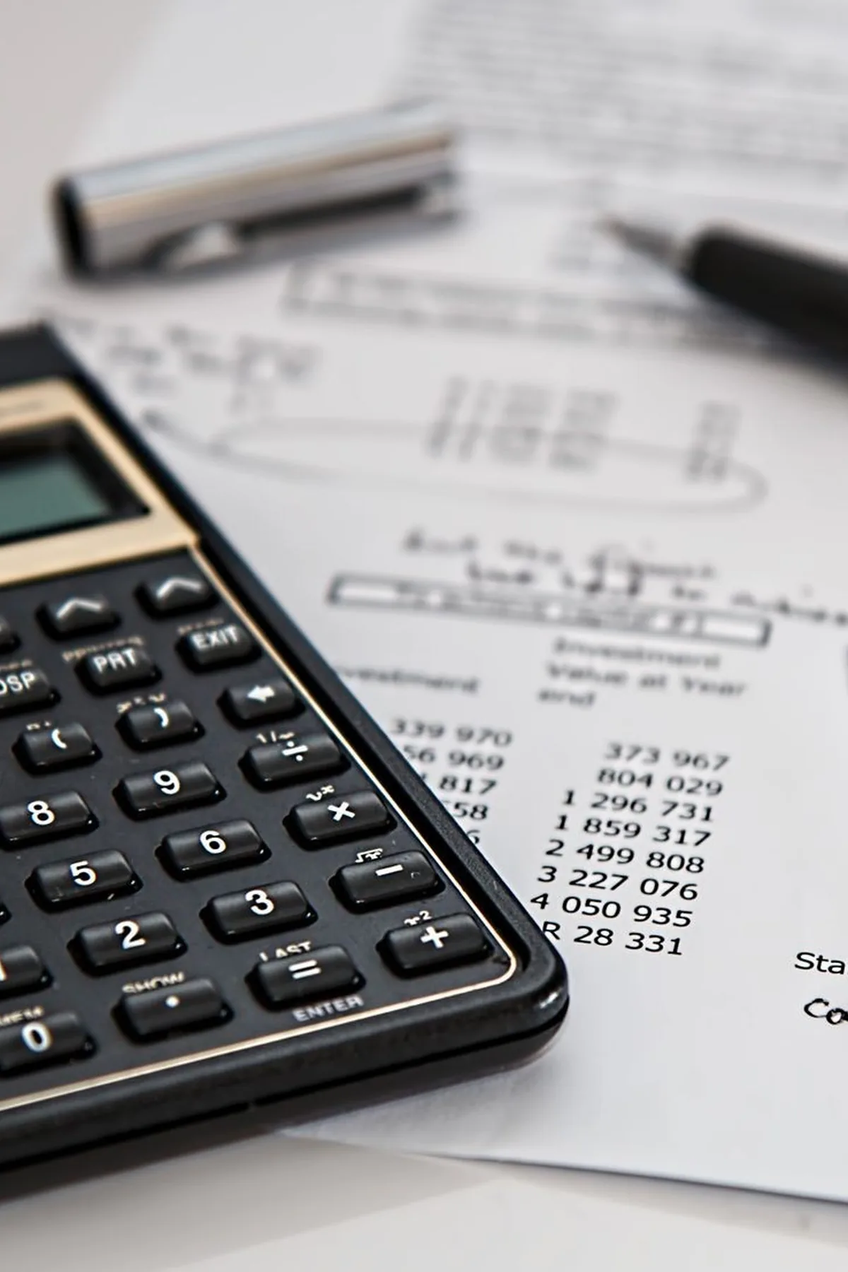 Close-up of financial documents with calculator and pen, ideal for business management themes.
