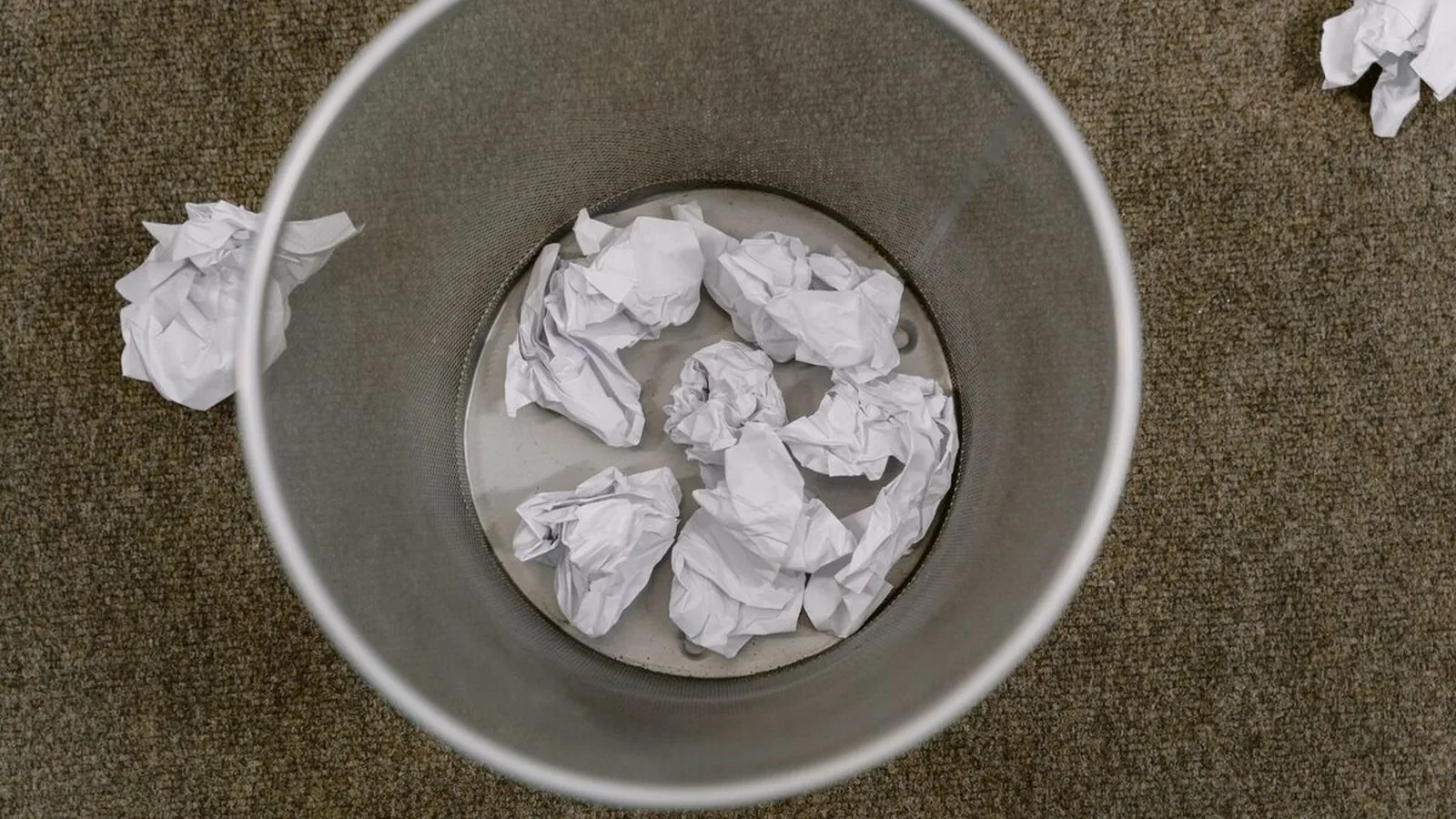 Kosz na śmieci wypełniony zmiętymi kartkami papieru, widok z góry