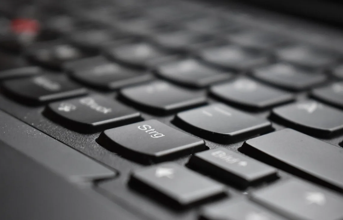 Zbliżenie na czarną klawiaturę laptopa biznesowego z czerwonym trackpointem