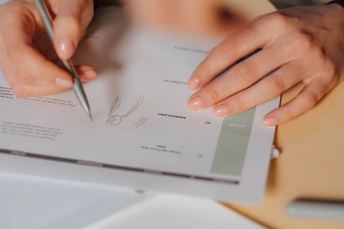 Close-up view of hands writing on a document, emphasizing note-taking and writing.