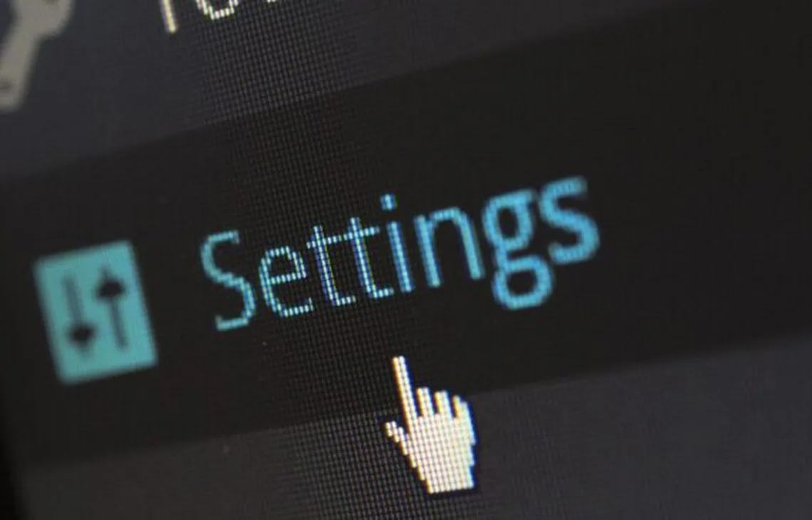 Zbliżenie ekranu z napisem Settings i kursorem myszy