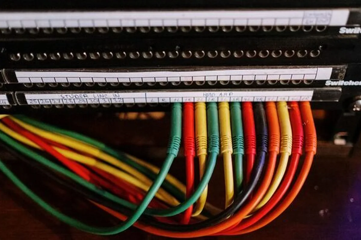 panel krosowniczy z kolorowymi kablami sieciowymi podłączonymi do portów