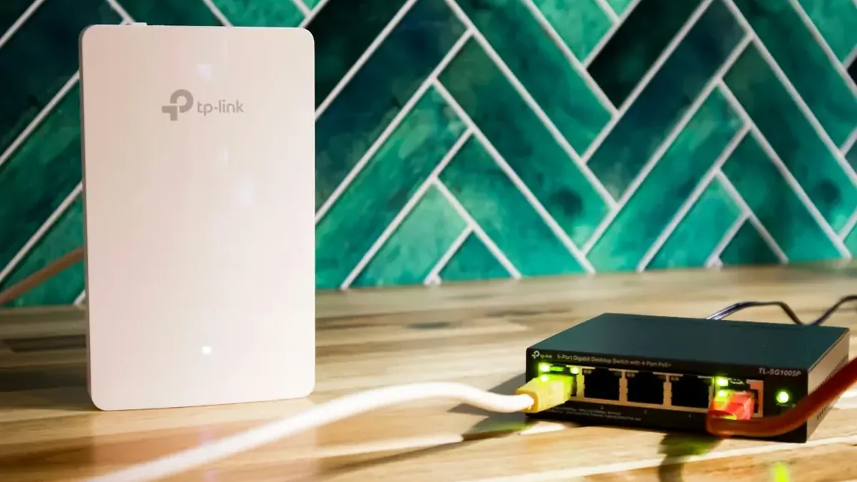 punkt dostępowy Wi-Fi TP-Link i przełącznik sieciowy na biurku