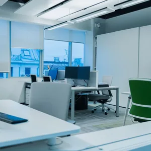 Bright and modern office environment with computer workstations and large windows.