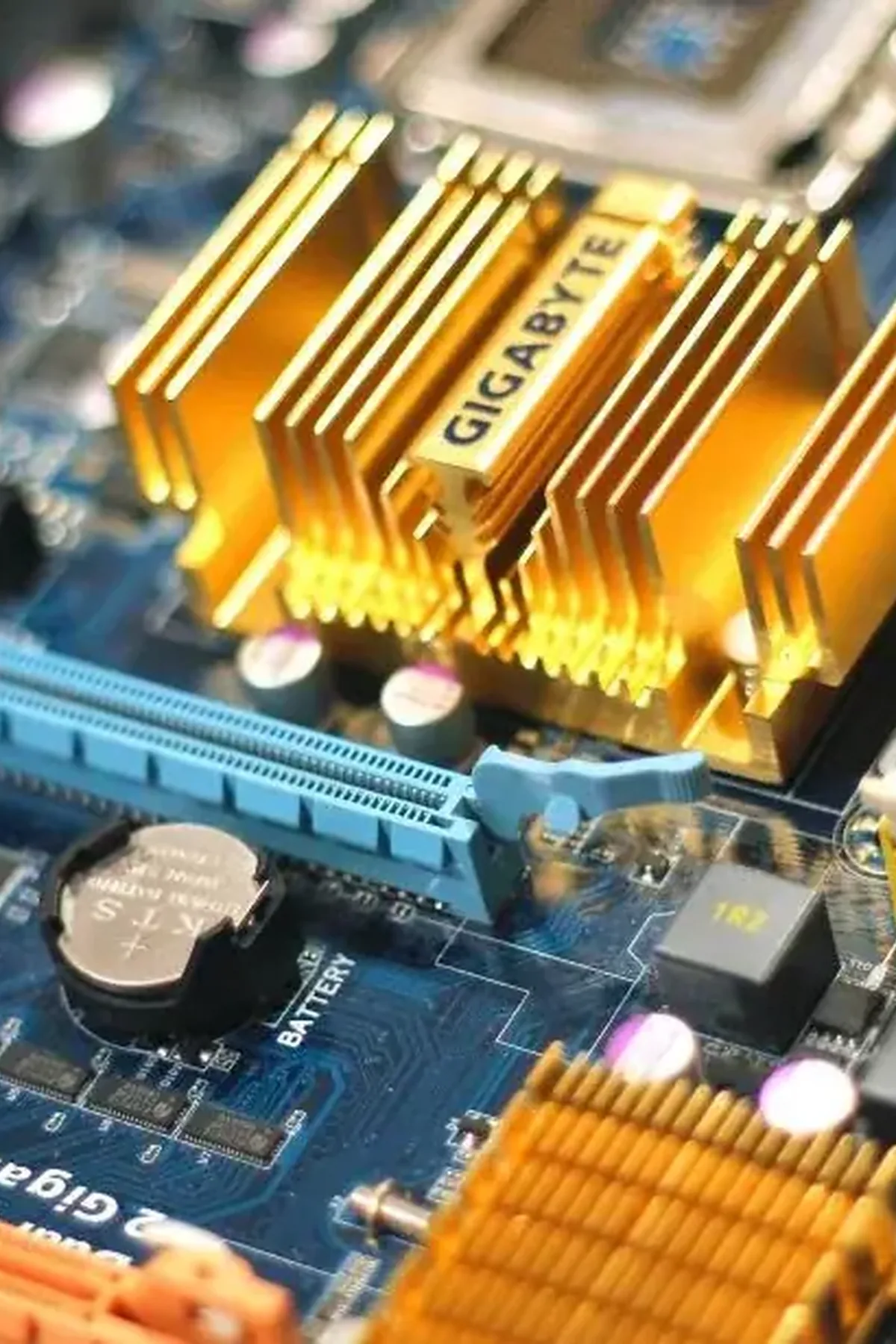 zbliżenie płyty głównej Gigabyte ze złotym radiatorem i modułami RAM