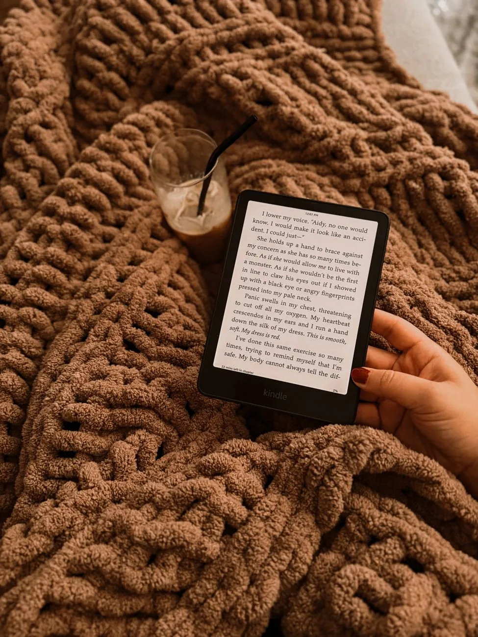 dłoń z czytnikiem e-booków na kocu obok mrożonej kawy — Amazon Kindle Paperwhite 2 a zakres naszego serwisu — czym zajmujemy się zamiast