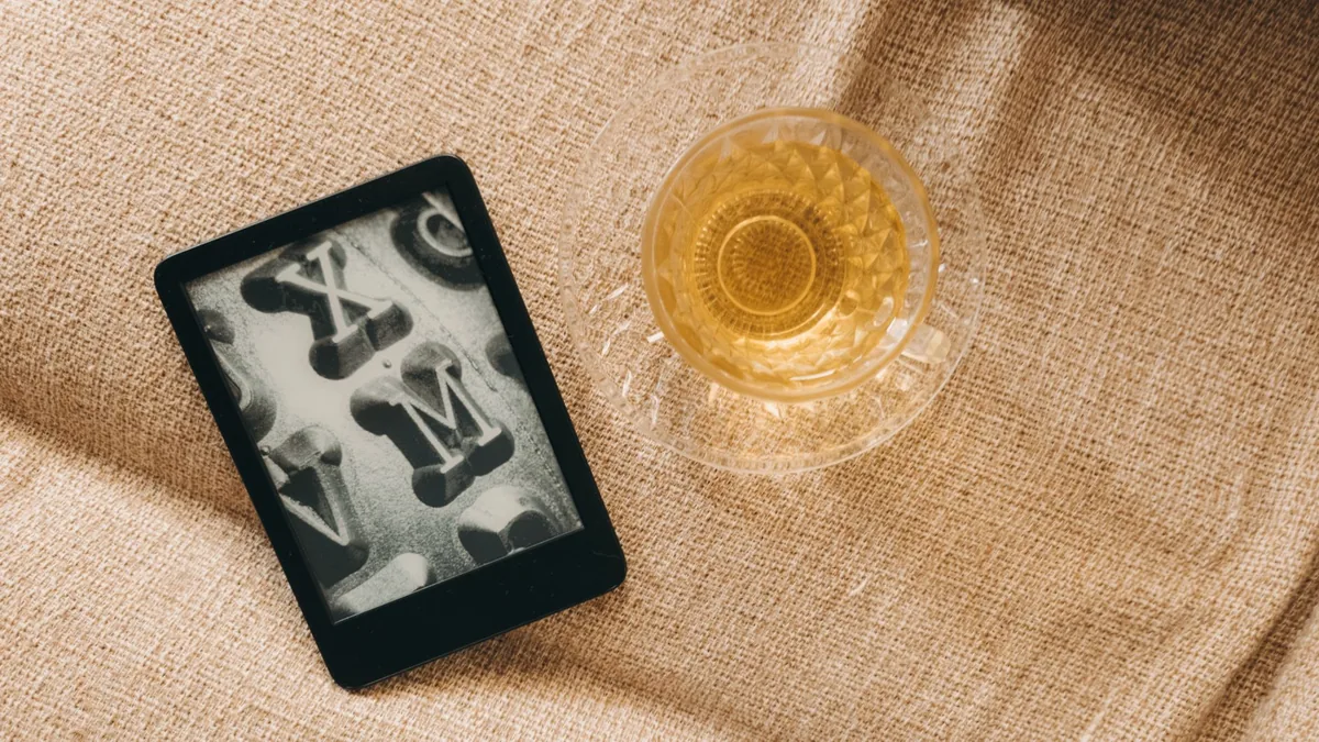 czytnik e-booków obok kubka herbaty na płótnie — Amazon Kindle Paperwhite 4 poza naszym warsztatem — gdzie szukać pomocy