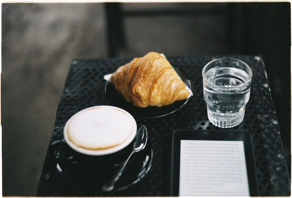 czytnik e-booków, rogalik i cappuccino na stoliku — Amazon Kindle Voyage poza naszym warsztatem — gdzie szukać pomocy