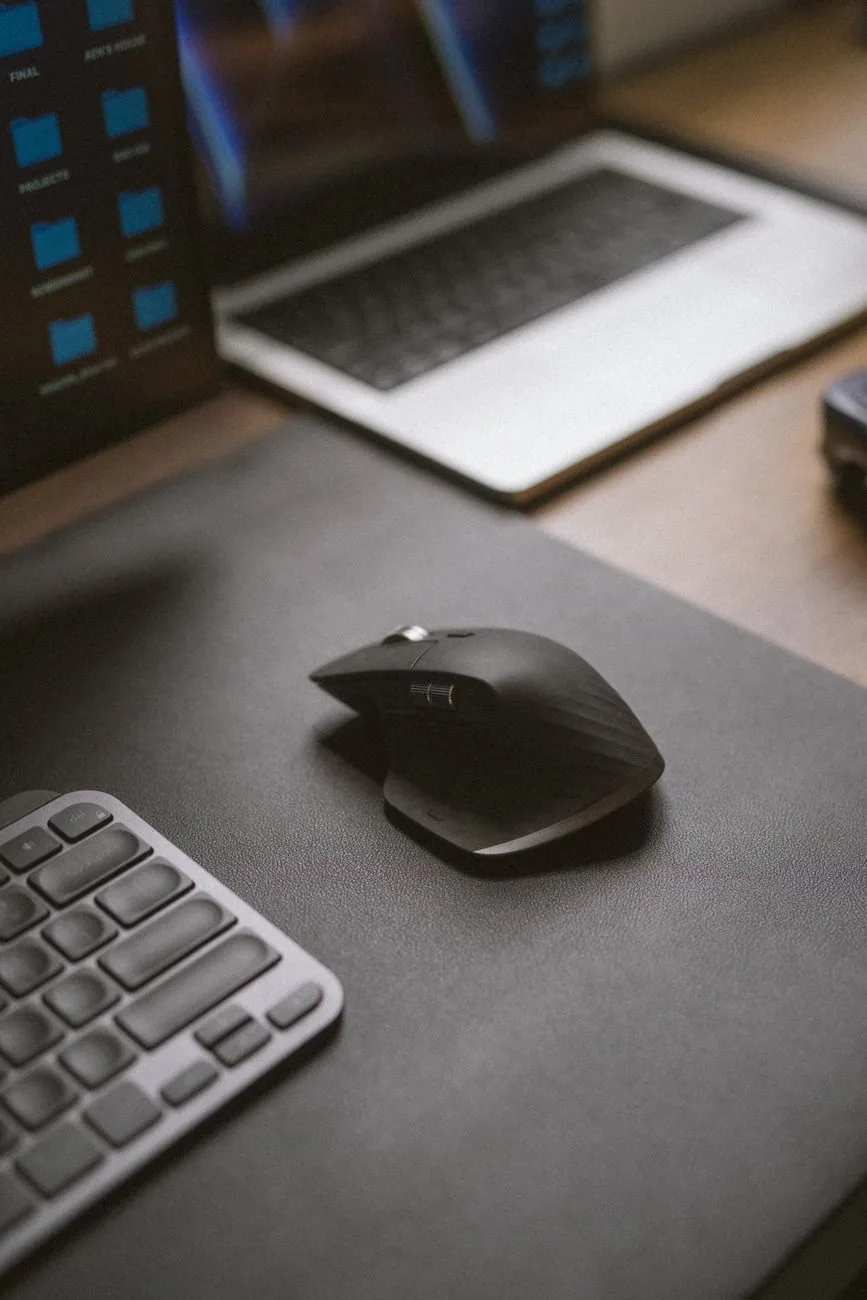 czarna bezprzewodowa mysz obok laptopa i klawiatury na biurku — Apple Magic Trackpad a zakres naszego serwisu — czym zajmujemy się zamiast