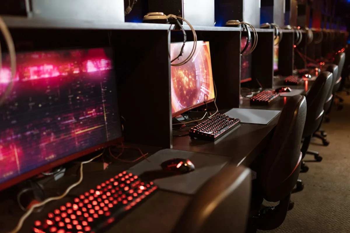 rząd podświetlanych monitorów i klawiatur na arenie esportowej — ASUS ROG Strix XG27AQ poza naszym warsztatem — gdzie szukać pomocy