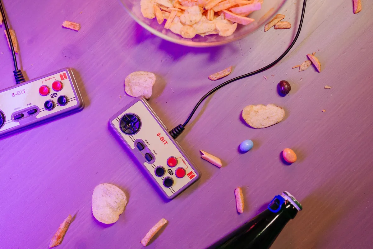 kontrolery do gier retro obok przekąsek na stole — Atari VCS a zakres naszego serwisu — czym zajmujemy się zamiast