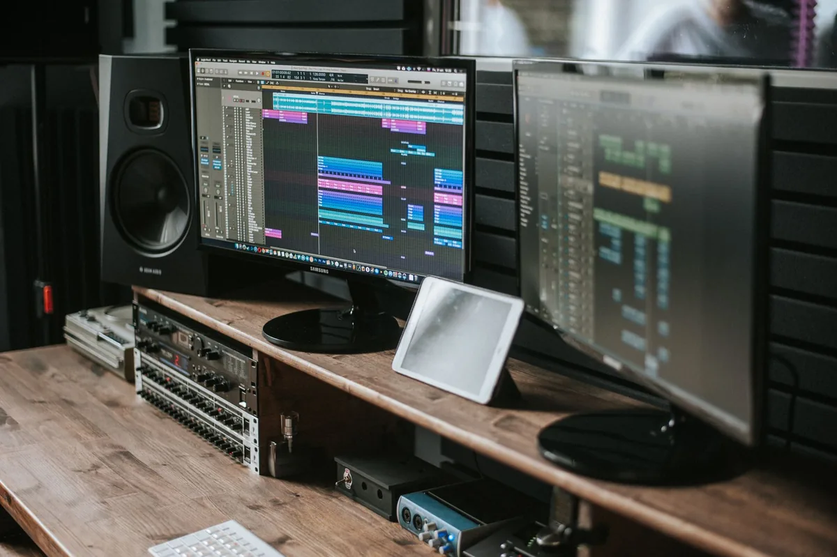 dwa monitory z programem audio na drewnianym biurku — BenQ GW2475H a zakres naszego serwisu — czym zajmujemy się zamiast
