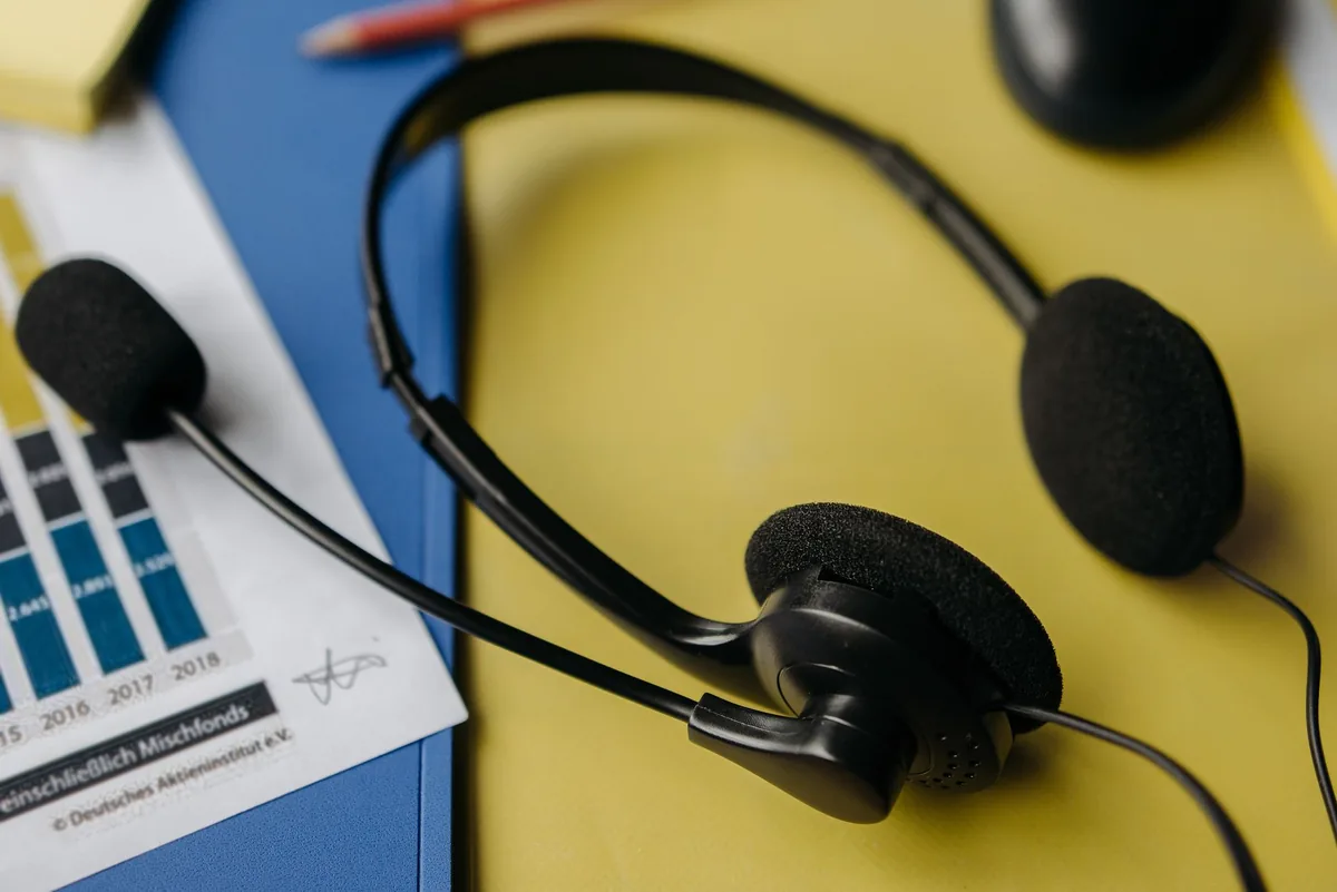 zestaw słuchawkowy na biurku z dokumentami i przyborami biurowymi — Blue Yeti Nano poza naszym warsztatem — gdzie szukać pomocy