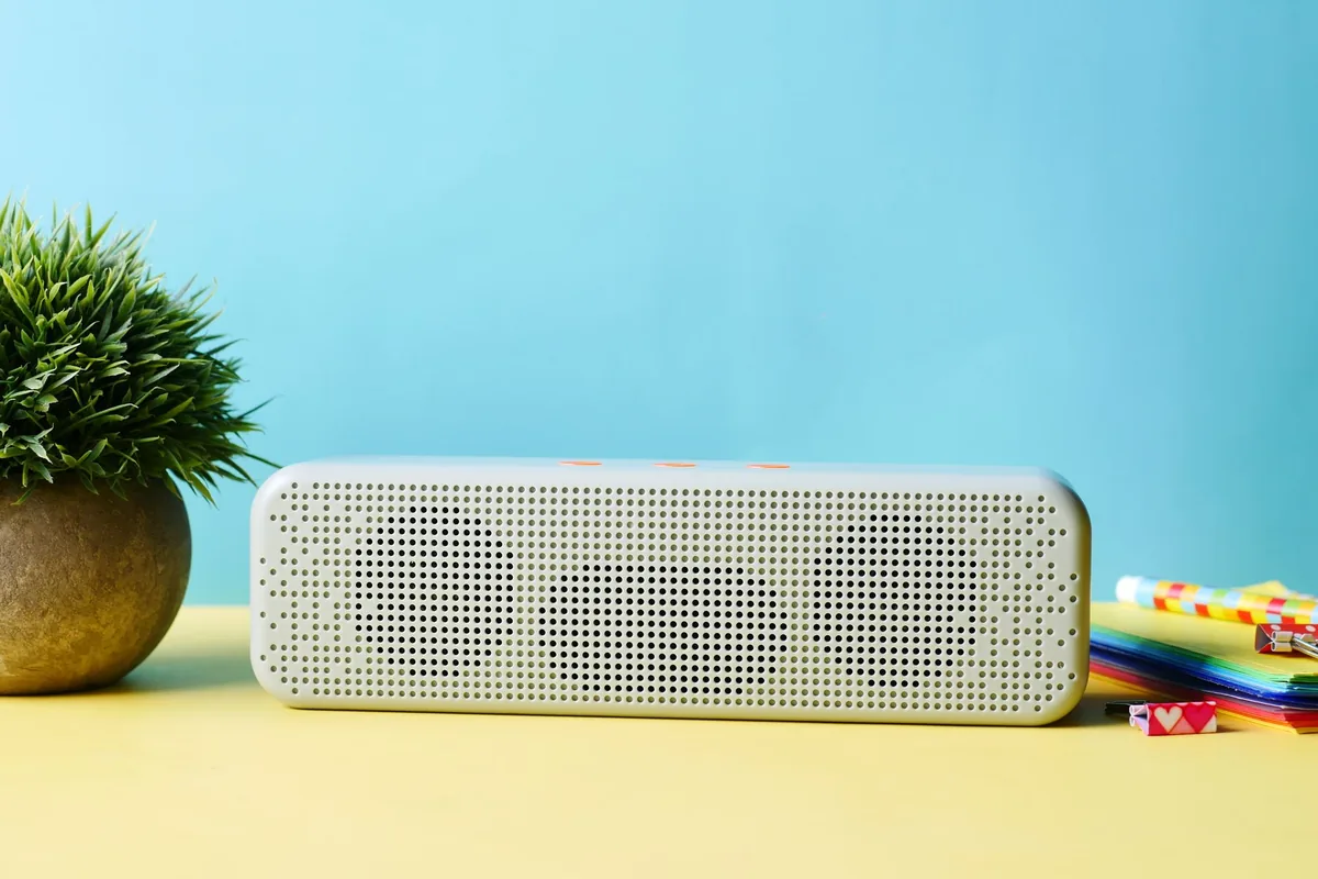 głośnik bezprzewodowy obok rośliny doniczkowej i przyborów biurowych — Bluesound Powernode w zgłoszeniu — jak odpowiadamy i co radzimy