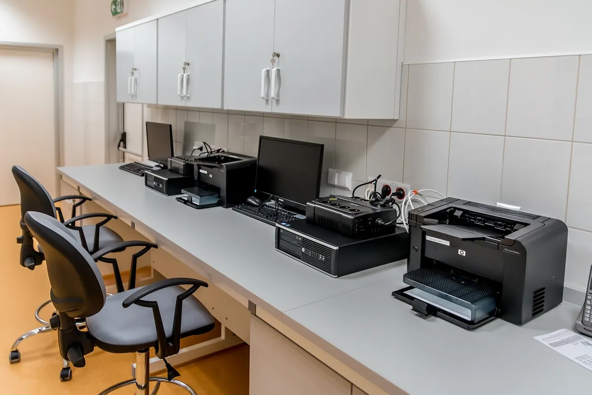 drukarka laserowa obok monitora komputerowego w biurze — Canon i-SENSYS LBP6030 w zgłoszeniu — jak odpowiadamy i co radzimy