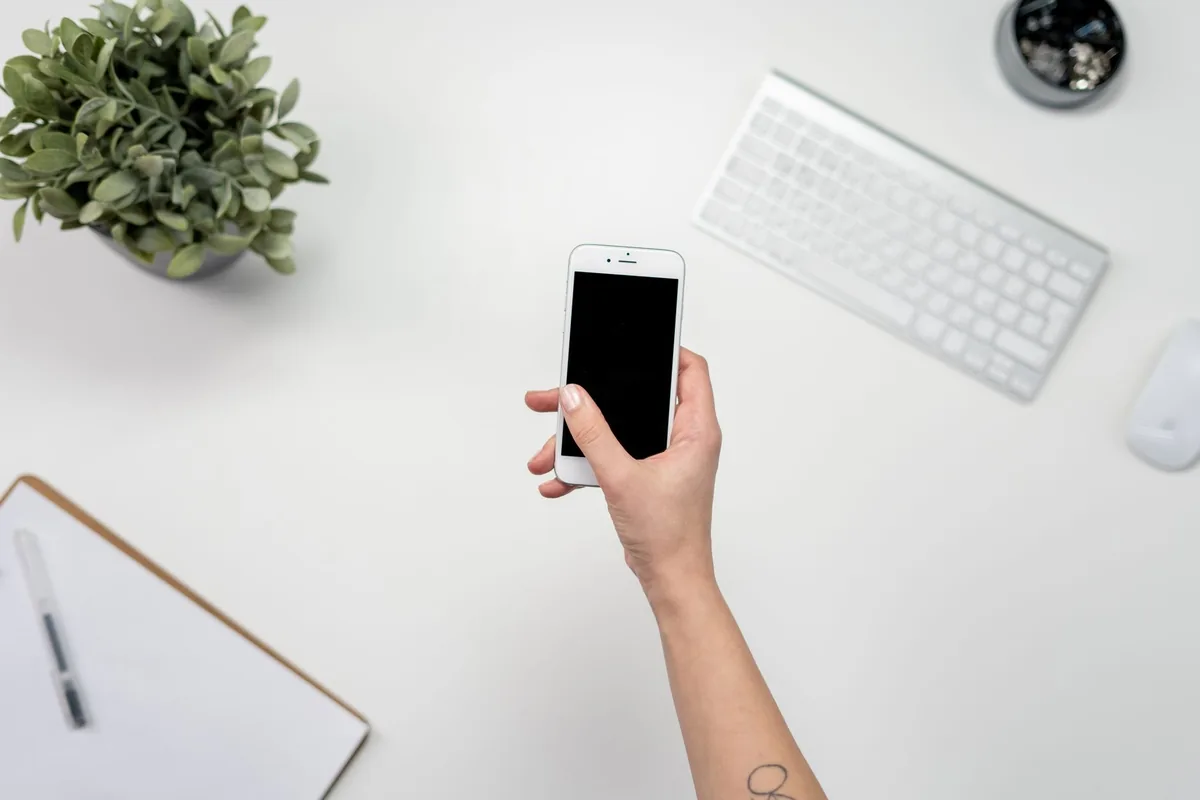 telefon komórkowy obok klawiatury i rośliny na biurku — CMF Phone 1 a zakres naszego serwisu — czym zajmujemy się zamiast