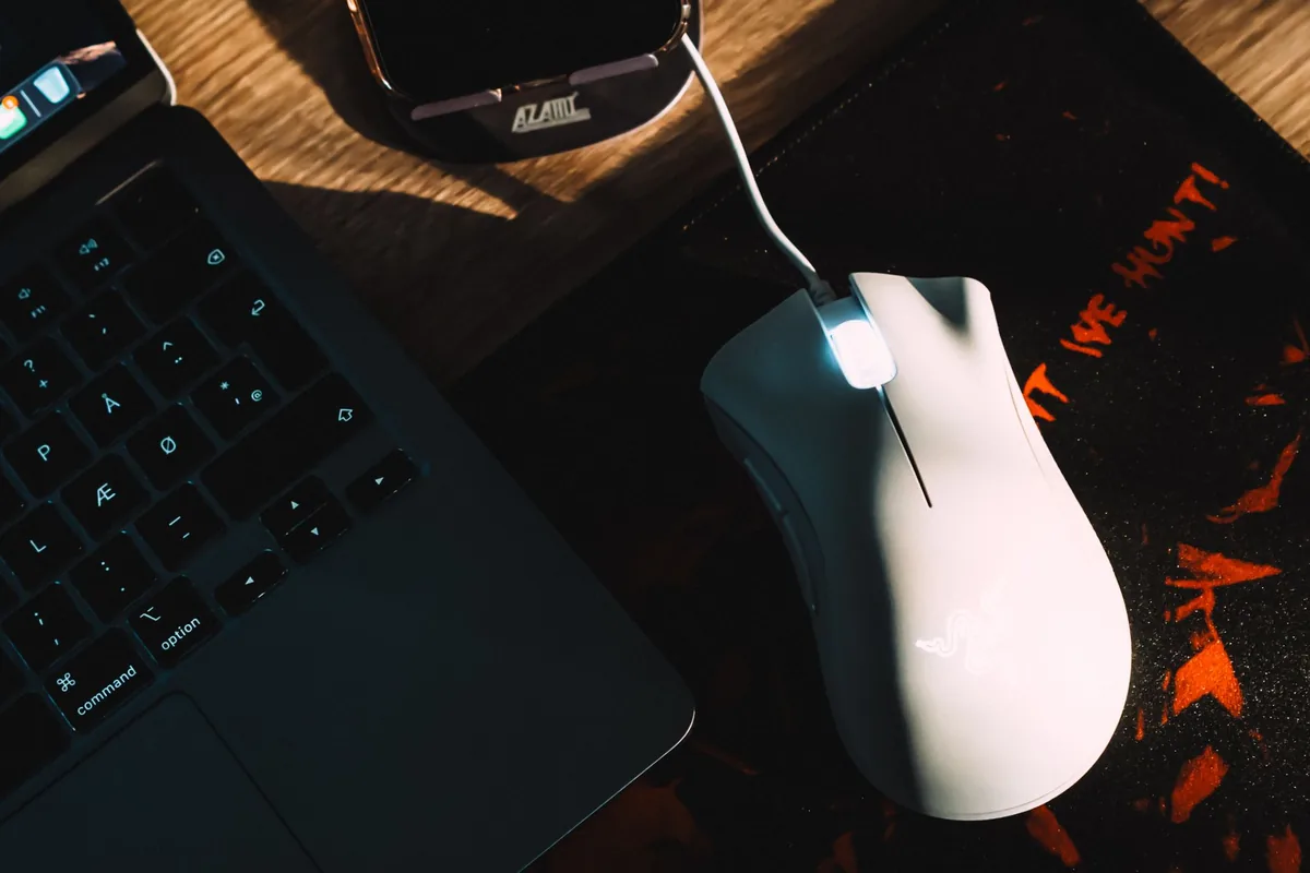 mysz gamingowa obok laptopa na biurku — Corsair M65 RGB Ultra — czego przy tym sprzęcie nie zrobimy