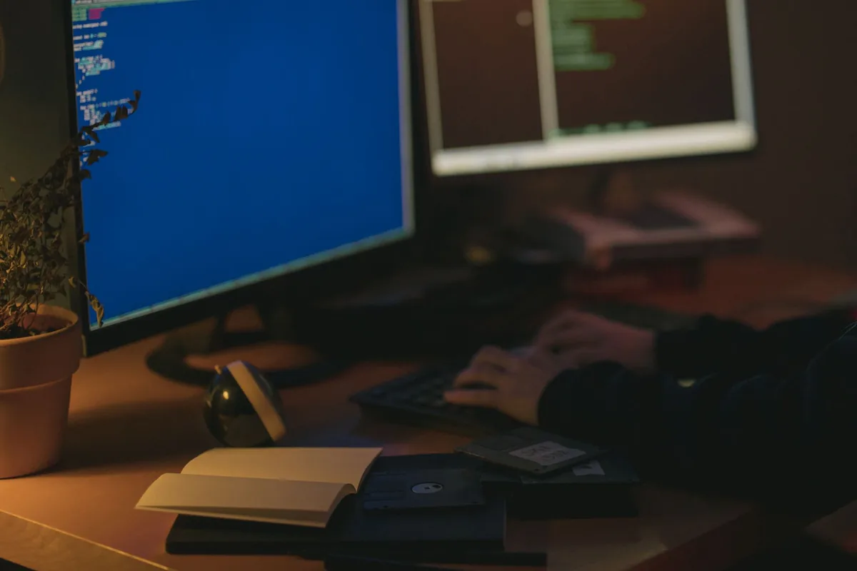 dwa monitory z kodem w przyciemnionym pomieszczeniu — Dell P2719H a zakres naszego serwisu — czym zajmujemy się zamiast