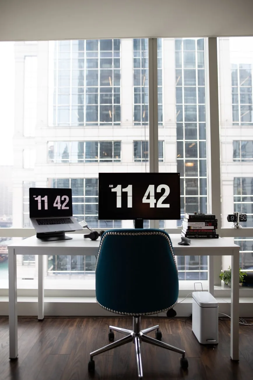 dwa monitory na biurku na tle panoramy miasta — Dell SE2722H w zgłoszeniu — jak odpowiadamy i co radzimy