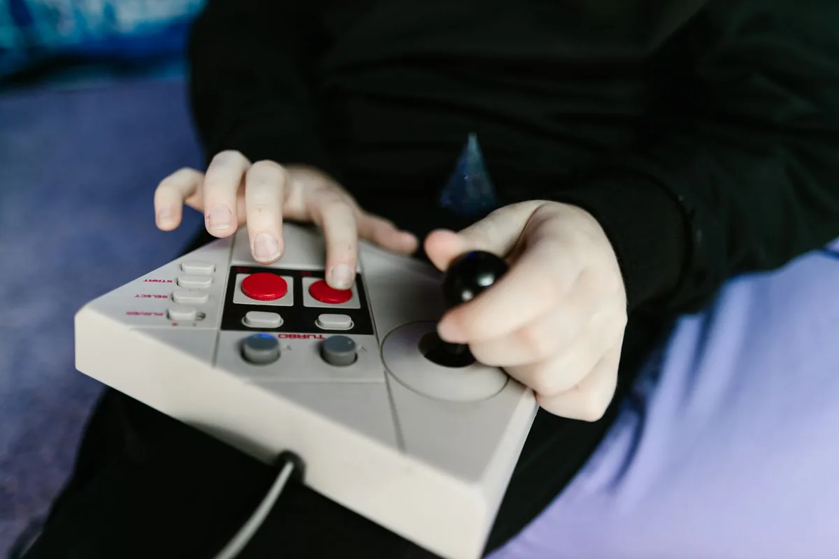 dłonie trzymające joystick do konsoli retro — Dlaczego nie bierzemy Anbernic RG405M do naprawy
