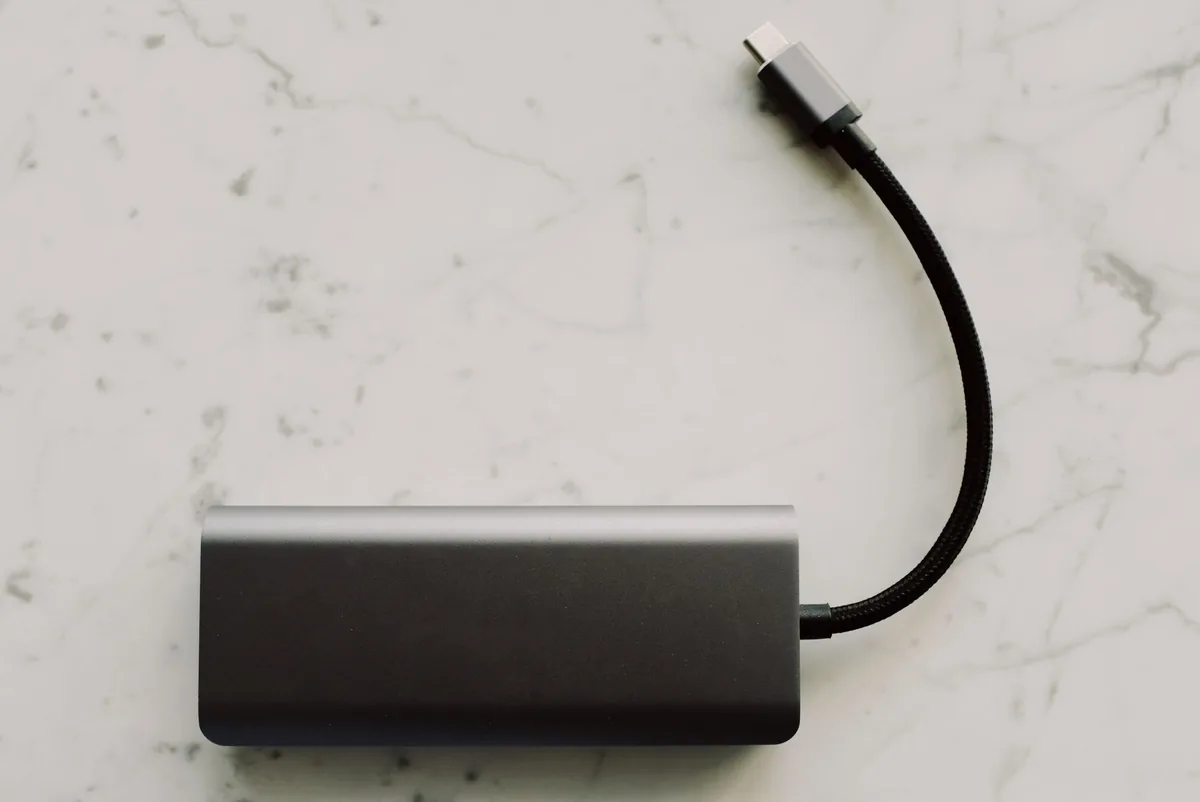 powerbank z kablem USB-C na marmurowym stole — Dlaczego nie bierzemy Dell DA310 do naprawy