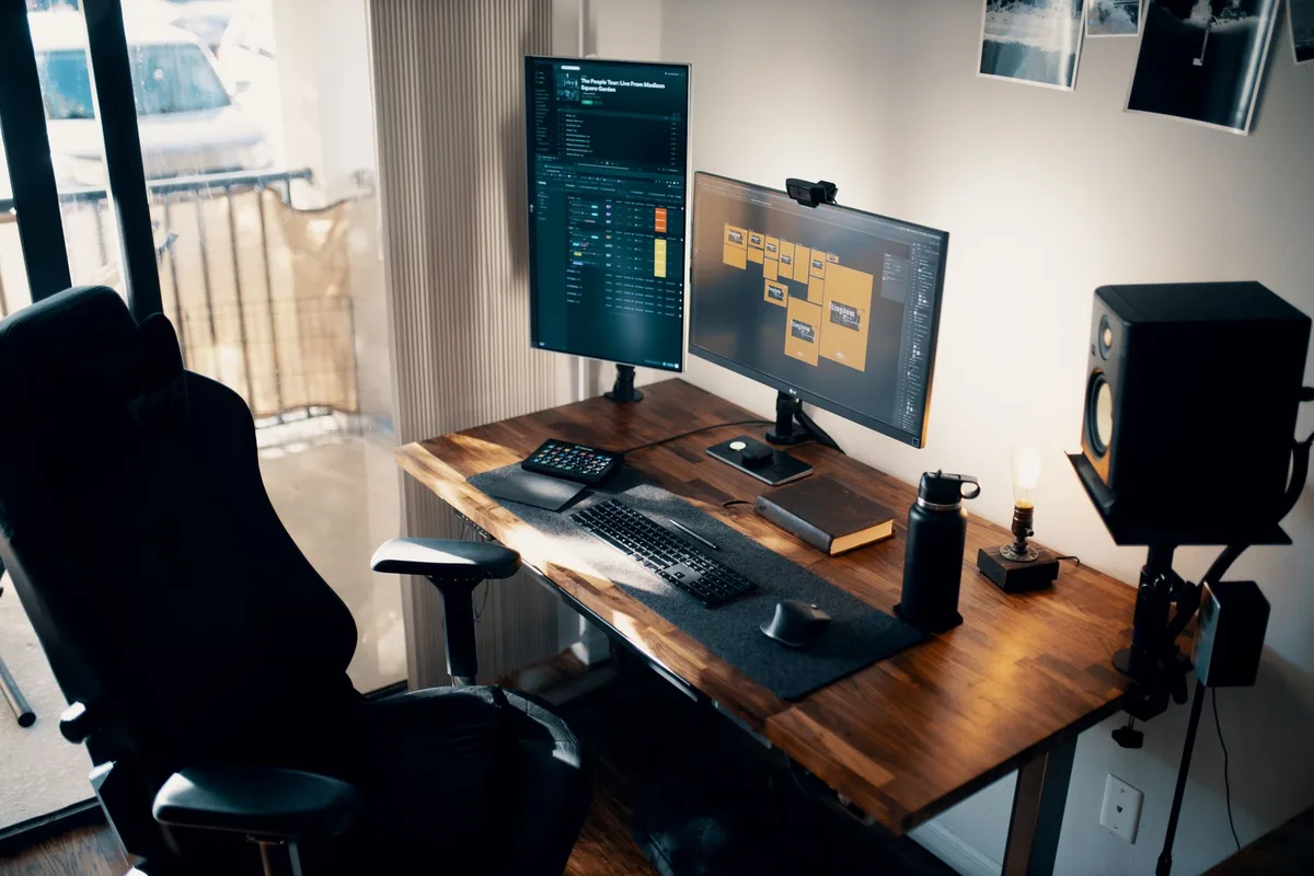 dwa monitory na drewnianym biurku z fotelem ergonomicznym — Dlaczego nie bierzemy Fujitsu B24-9 TS do naprawy