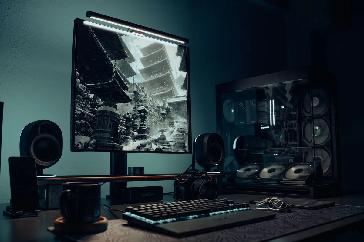 monitor z grafiką świątyni i podświetlany komputer na biurku — Dlaczego nie bierzemy Gigabyte M27U do naprawy