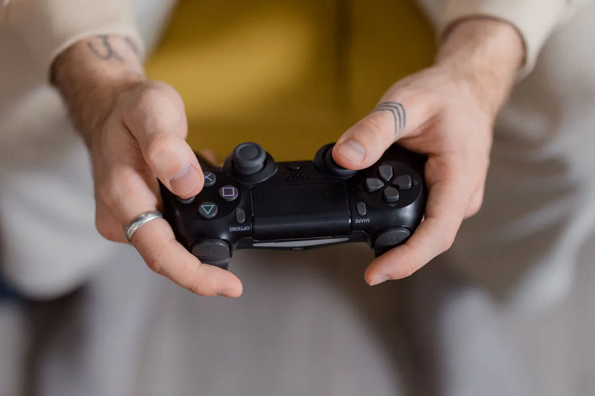 dłonie trzymające czarny kontroler do gier — Dlaczego nie bierzemy Google Stadia Controller do naprawy