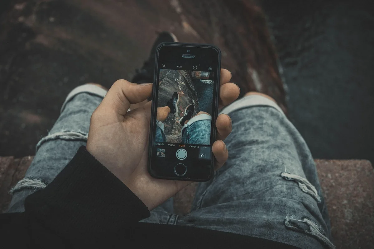 dłoń trzymająca szary smartfon na tle betonu — Dlaczego nie bierzemy Honor Magic V2 do naprawy