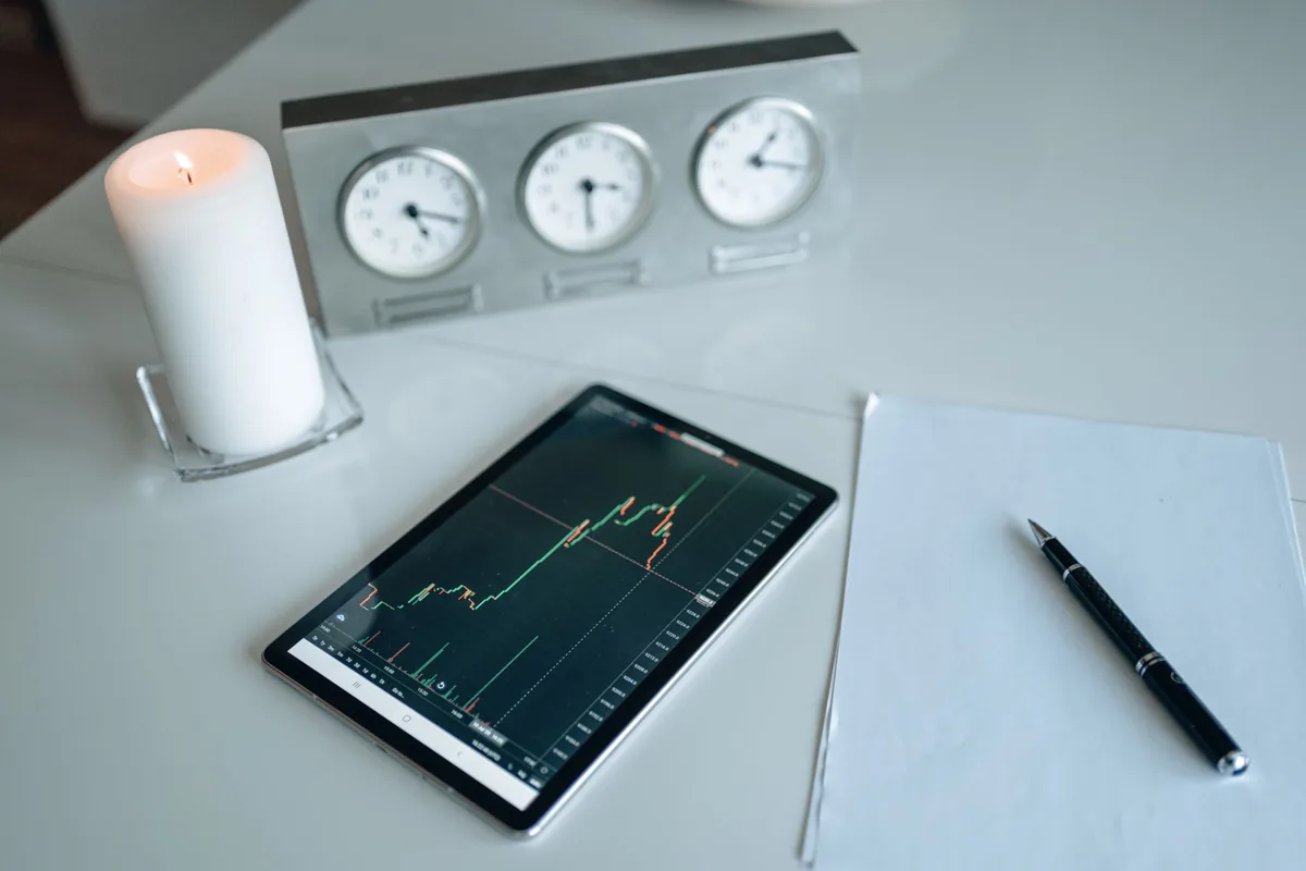 tablet z wykresem giełdowym na biurku obok świecy i dokumentów — Dlaczego nie bierzemy Huawei MediaPad M3 do naprawy