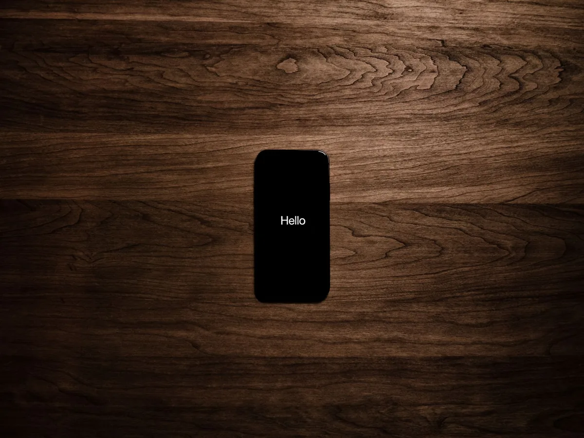 smartfon z napisem na ekranie na ciemnym drewnianym tle — Dlaczego nie bierzemy Huawei Nova 8i do naprawy