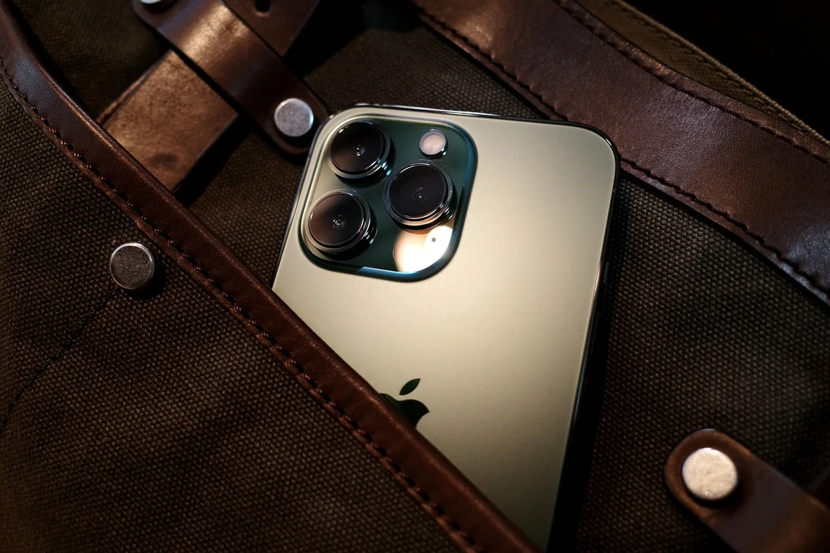 zielony iphone 13 pro obok płóciennej torby — Dlaczego nie bierzemy iPhone 13 mini do naprawy