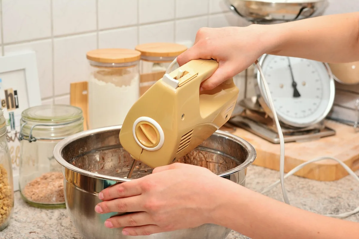 dłonie przygotowujące ciasto za pomocą miksera — Dlaczego nie bierzemy KitchenAid Artisan 5KSM125 do naprawy