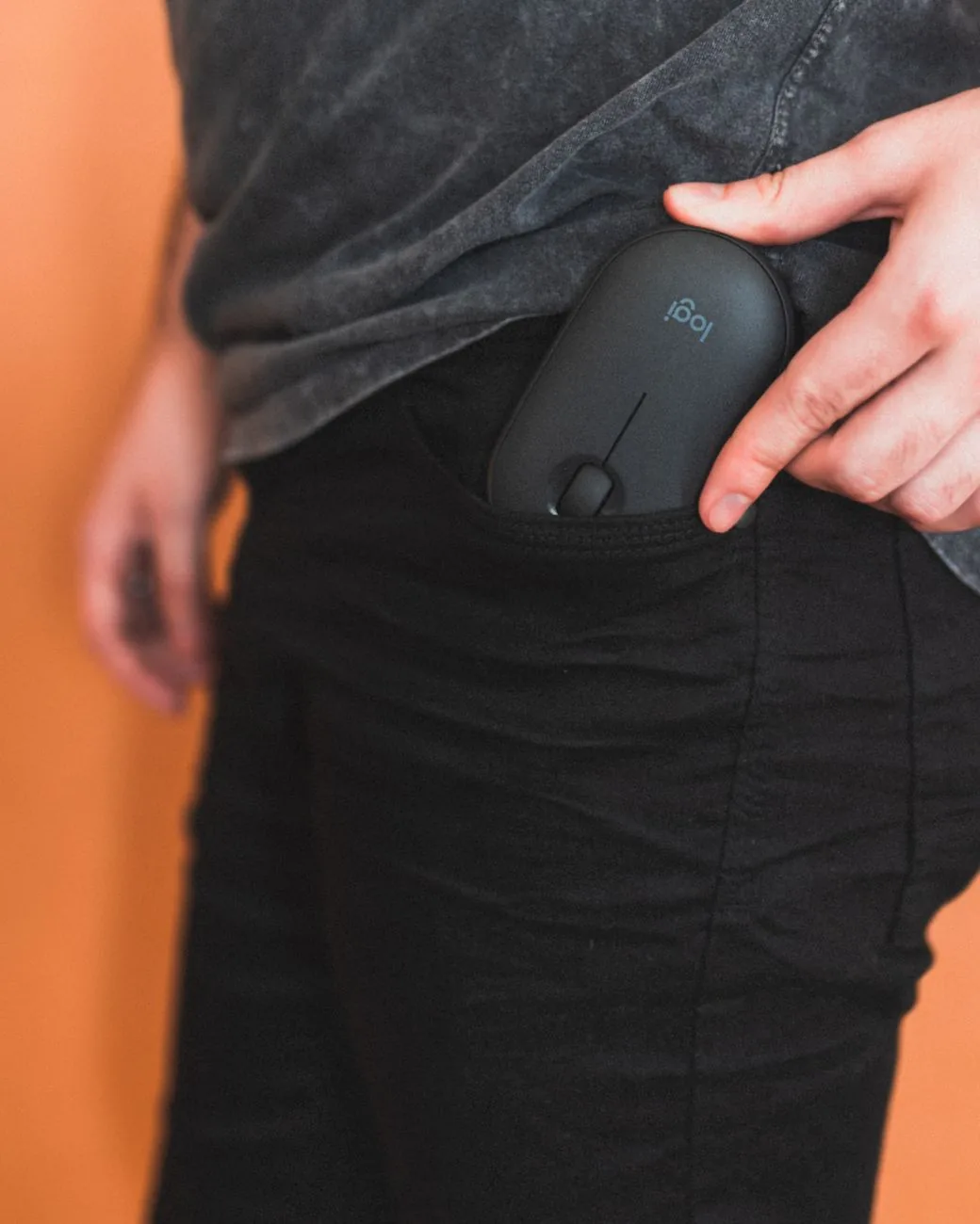 dłoń wkładająca małą mysz bezprzewodową do kieszeni spodni — Dlaczego nie bierzemy Logitech M705 Marathon do naprawy